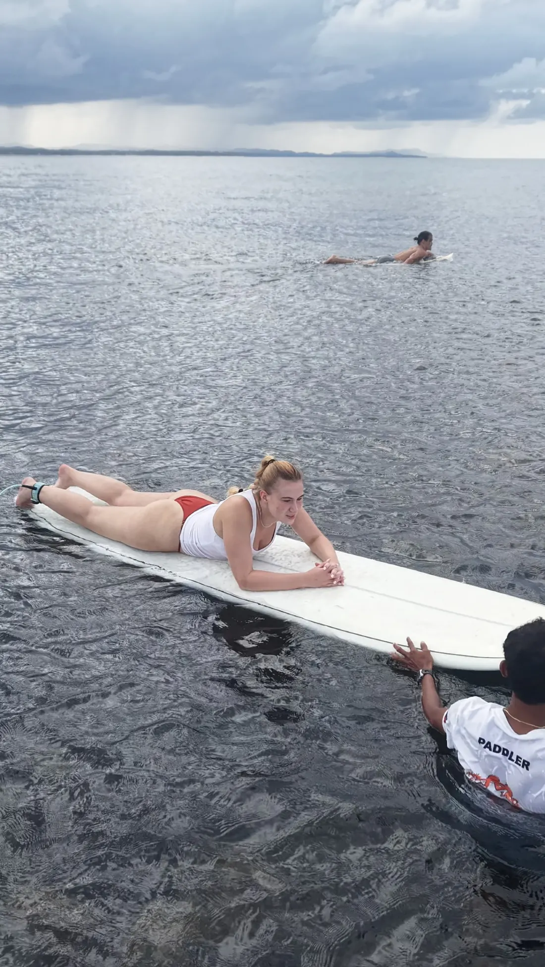 Coach pushing a student into a wave